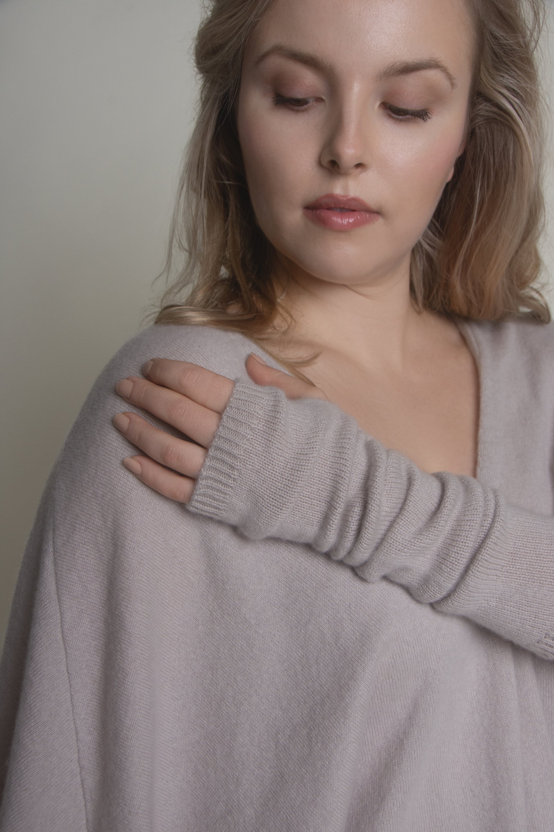 portrait of woman in beige cashmere arm warmers with relaxed pose