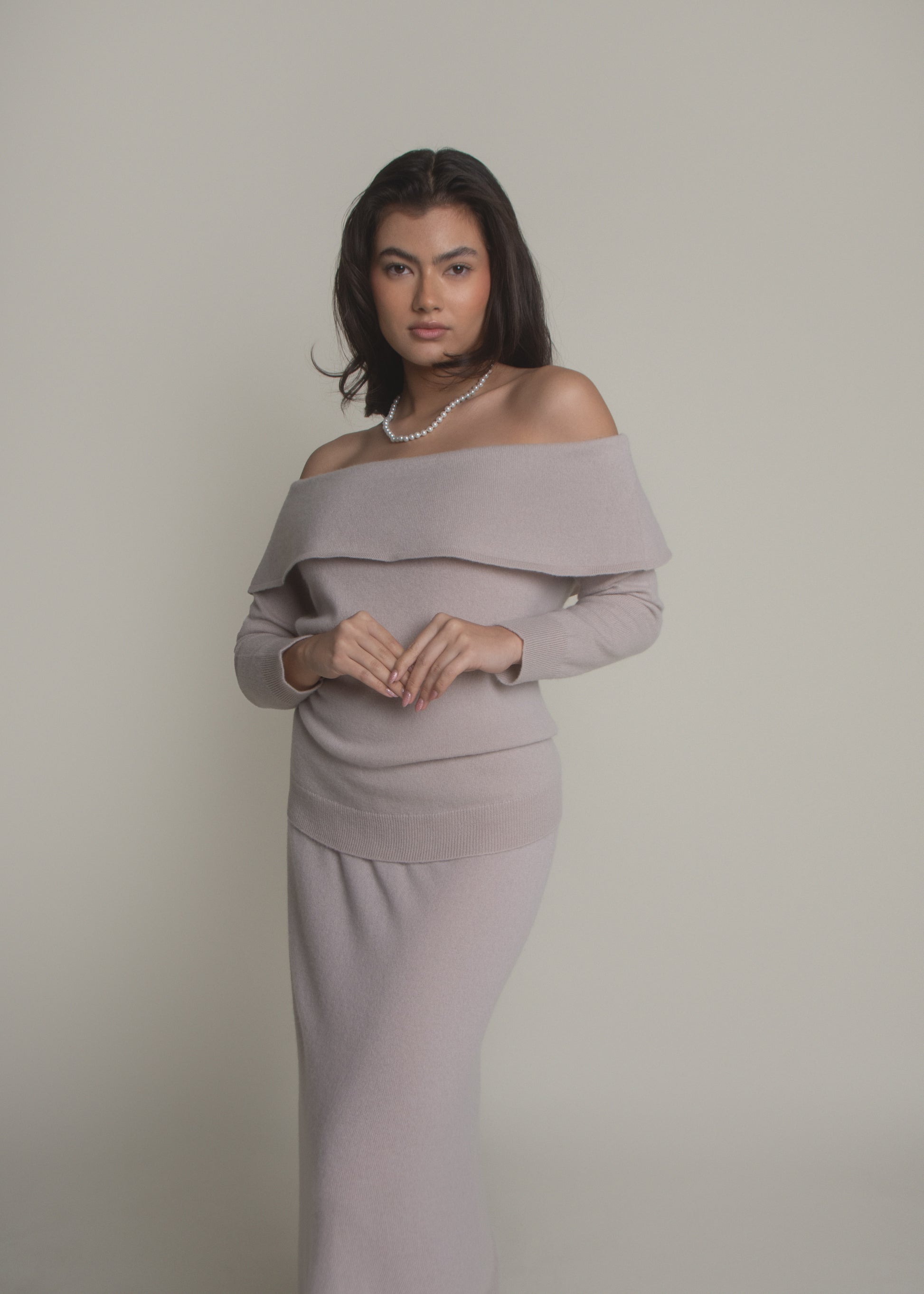 woman wearing beige off-shoulder cashmere sweater front view