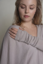 portrait of woman in beige cashmere arm warmers with relaxed pose