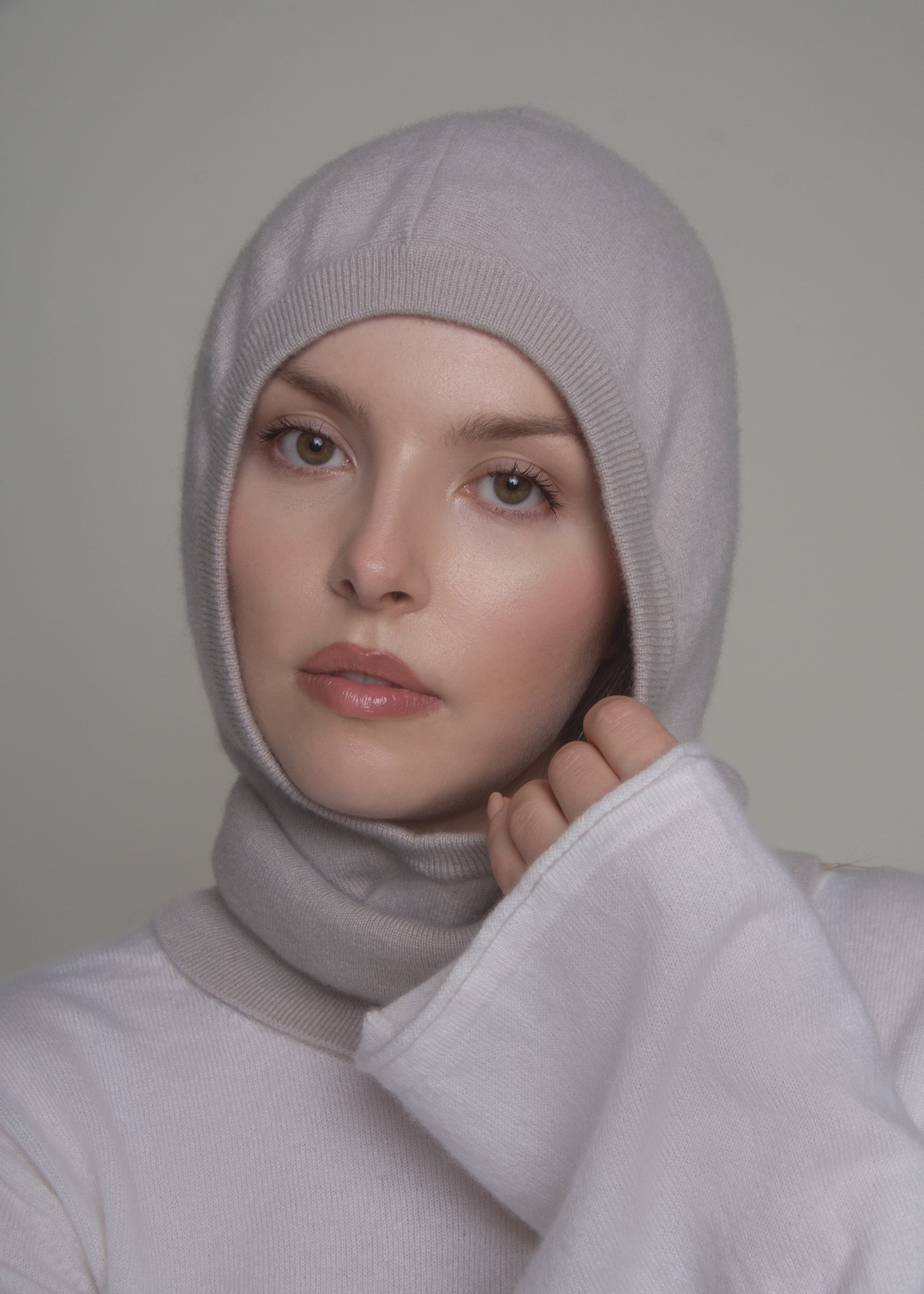 portrait of woman in light cashmere balaclava hood looking sideways