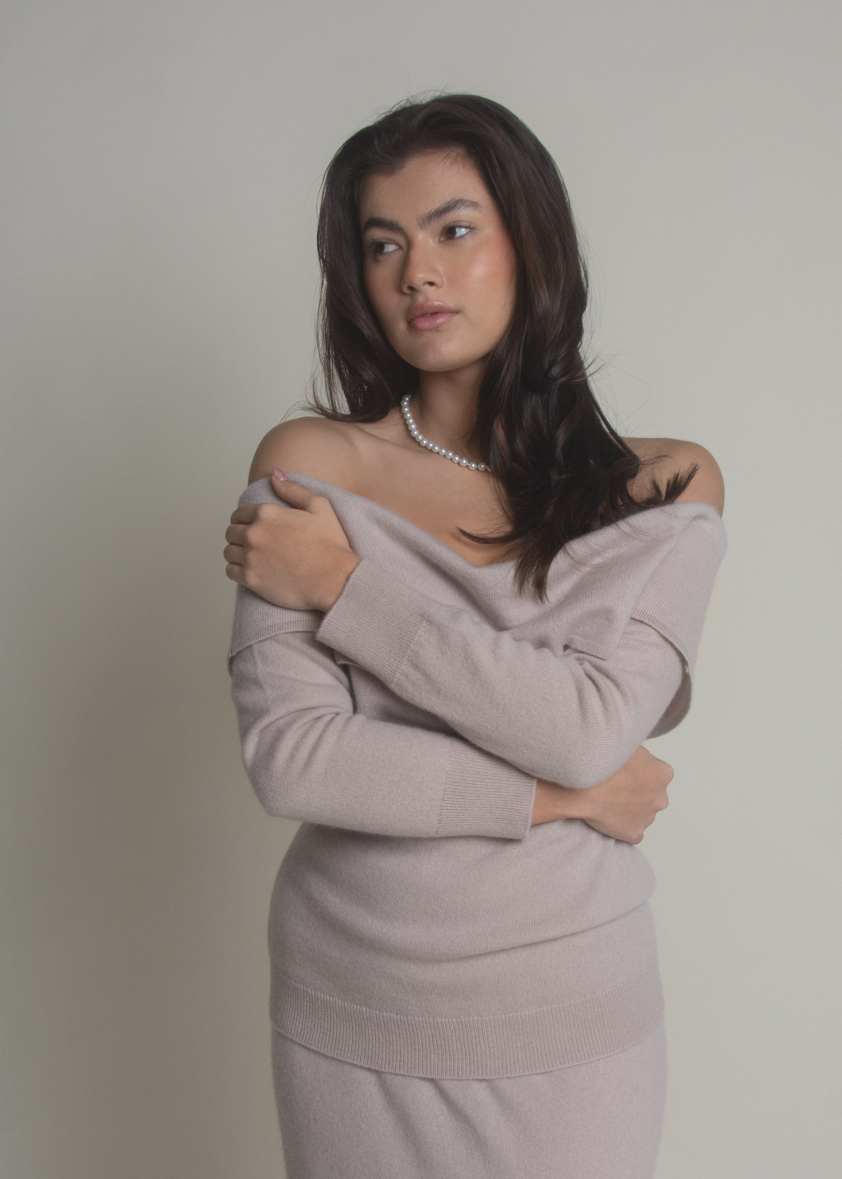 woman in beige off-shoulder cashmere sweater with relaxed fit